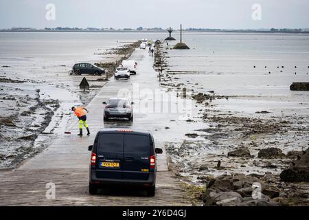 Île de Noirmoutier (ouest de la France) : passage du Gois ou Goa, passage naturel périodiquement inondé. Nettoyage des routes avant ouverture à la circulation. Voitures Banque D'Images