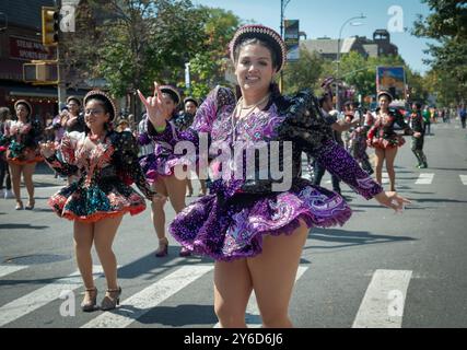 Une heureuse bolivienne américaine marche et danse dans un costume coloré. Au défilé du jour hispanique du Queens 2024 à Jackson Heights. Banque D'Images