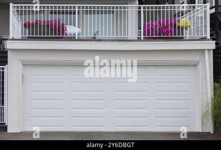 Porte de garage. Maison moderne avec porte de garage blanche qui est fermée. Un quartier parfait. Maison familiale avec large porte de garage et allée en béton en f Banque D'Images