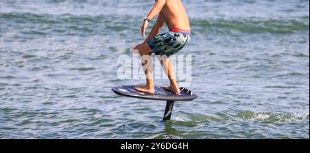 Vue latérale d'un homme chevauchant un kite board hydrofooting dans l'océan Atlantique. Banque D'Images