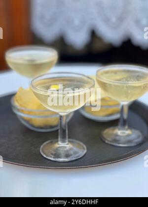 Trois cocktails sur un plateau de bar avec chips ou crêpes de pommes de terre. Pris dans un bar en plein air. Banque D'Images