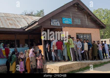 Budgam, Inde. 25 septembre 2024. Les électeurs cachemiris attendent dans une file d'attente pour voter devant le bureau de vote pendant la deuxième phase des élections à l'Assemblée du Jammu-et-Cachemire à Budgam, au sud-ouest de Srinagar. Il s'agit des premières élections d'Assemblée locale en une décennie et des premières depuis que New Delhi a révoqué le statut semi-autonome de la région en 2019, la plaçant sous domination directe. Près de neuf millions de personnes sont inscrites sur les listes électorales dans la région contestée, traditionnellement connue pour ses boycotts visant à protester contre la domination indienne. Crédit : SOPA images Limited/Alamy Live News Banque D'Images