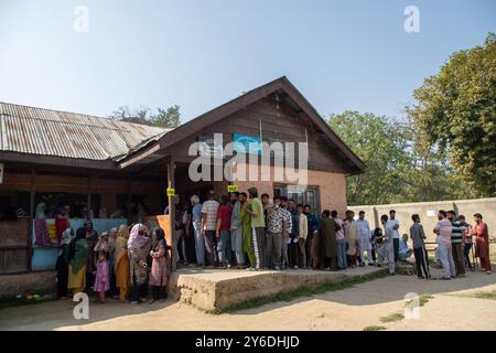 Budgam, Inde. 25 septembre 2024. Les électeurs cachemiris attendent dans une file d'attente pour voter devant le bureau de vote pendant la deuxième phase des élections à l'Assemblée du Jammu-et-Cachemire à Budgam, au sud-ouest de Srinagar. Il s'agit des premières élections d'Assemblée locale en une décennie et des premières depuis que New Delhi a révoqué le statut semi-autonome de la région en 2019, la plaçant sous domination directe. Près de neuf millions de personnes sont inscrites sur les listes électorales dans la région contestée, traditionnellement connue pour ses boycotts visant à protester contre la domination indienne. Crédit : SOPA images Limited/Alamy Live News Banque D'Images