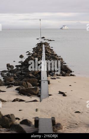 Photo d'une structure de fortification en pierre s'étendant dans la mer depuis la plage Banque D'Images