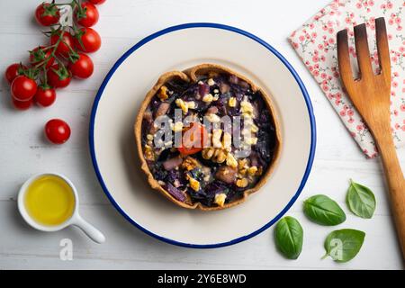 Quiche végétalienne individuelle avec légumes et chou rouge. Table vue sur le dessus avec décoration. Banque D'Images