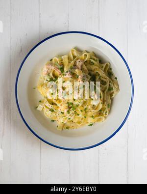 Pâtes italiennes fraîches au saumon et à la crème. Table vue sur le dessus avec décorations. Banque D'Images