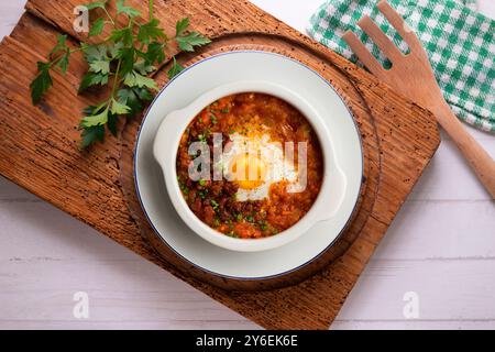 Tapa espagnole d'oeuf cuit au four avec chorizo ​​and tomate. Table vue sur le dessus avec décorations. Banque D'Images