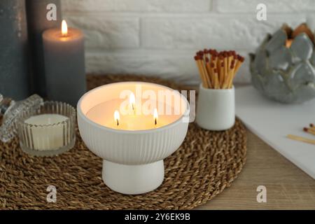 Bougies allumées et décor sur la table près du mur de briques blanches Banque D'Images