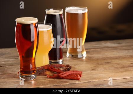 Verres avec différents types de bière et de collations sur la table en bois Banque D'Images