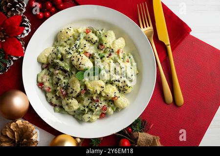 Délicieux gnocchi avec sauce yaourt et asperges vertes. Table vue sur le dessus avec décorations de Noël. Banque D'Images