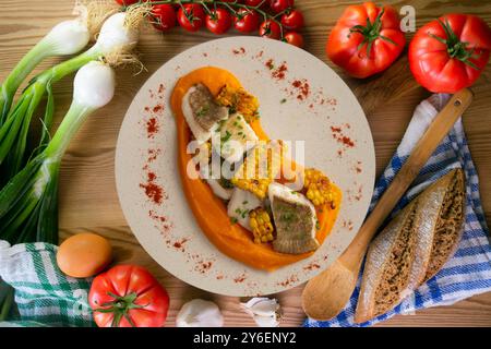 Délicieux poisson de sole avec crème de carottes et maïs. Table vue sur le dessus avec décorations. Banque D'Images