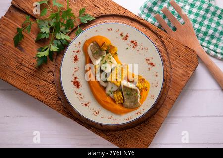 Délicieux poisson de sole avec crème de carottes et maïs. Table vue sur le dessus avec décorations. Banque D'Images