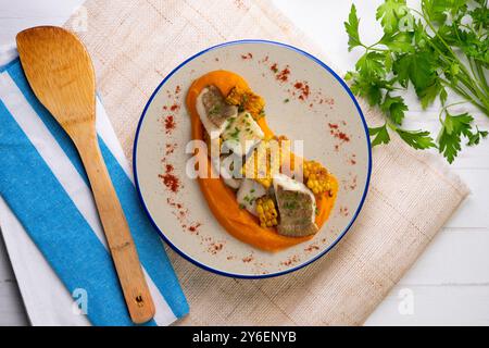 Délicieux poisson de sole avec crème de carottes et maïs. Table vue sur le dessus avec décorations. Banque D'Images