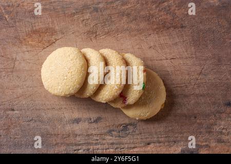 biscuits au sucre dispersés sur la surface de la table en bois ou le fond, biscuits sucrés cuits au four avec une texture croustillante et une saveur de beurre prise d'en haut Banque D'Images