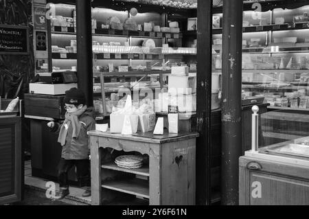 PARIS, FRANCE - 17 JANVIER 2015 : petit "client" non identifié sortant d'une fromagerie française avec des dizaines de sortes de fromages. Le fromage est l'un des th Banque D'Images