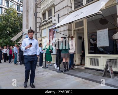 Les files d'attente des gens font la queue à l'extérieur, la Salad Kitchen pour le déjeuner à emporter, alors que les gens retournent au travail après le confinement Banque D'Images