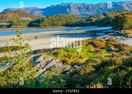 Un couple marchant sur la plage de Morar près de Mallaig connu sous le nom de Silver Sands, Écosse, Royaume-Uni Banque D'Images