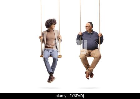 Homme jeune et mature assis sur des balançoires en bois et se regardant les uns les autres isolés sur fond blanc Banque D'Images