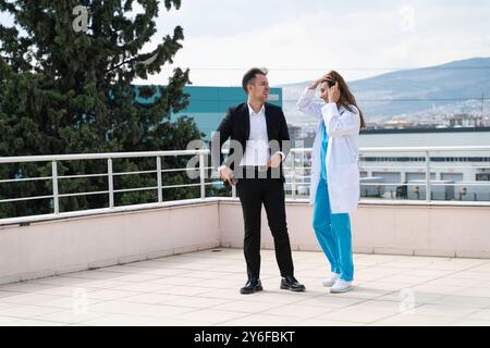 Portrait de cadre d'affaires et jeune femme médecin prenant une pause et s'engageant dans la conversation Banque D'Images