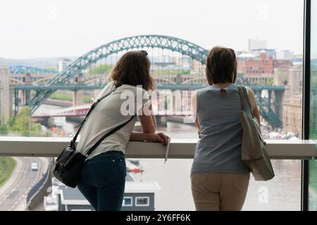 Personnes regardant les sites du quai de Gateshead et Newcastle en Angleterre,UK à partir de la fenêtre de visualisation à la Baltic Centre Banque D'Images