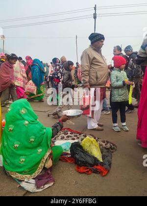 Prayagraj, UTTAR PRADESH, INDE - 14 AOÛT 2023 : jeune femme indienne mendiante avec son enfant mendiant dans la rue. Banque D'Images