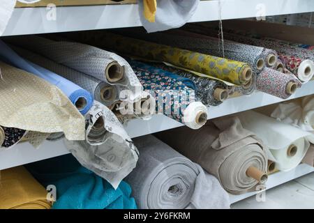 Image de rouleaux de divers tissus sur l'étagère d'un magasin de tissu d'habillement Banque D'Images