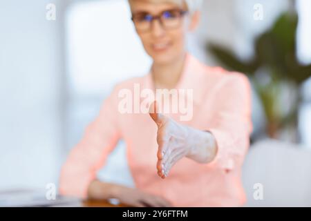 Femme D'Affaires Étirant La Main Pour Le Message D'Accueil Assis Au Bureau, Peu Profonde Profondeur Banque D'Images