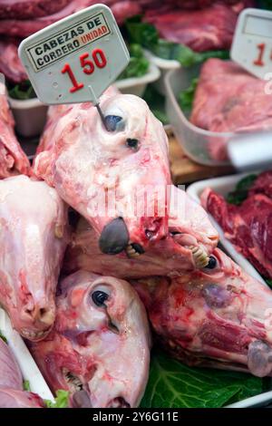 Une vue rapprochée des têtes d'agneau exposées à la vente au Mercat de la Boqueria, mettant en évidence la vie de marché dynamique à Barcelone. Banque D'Images