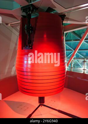 Le pendule amortisseur massique réglé rouge est installé au dernier étage d'une structure de grande hauteur, conçu pour réduire les oscillations du bâtiment pendant les vents violents ou l'activité sismique et assurer la stabilité. Banque D'Images