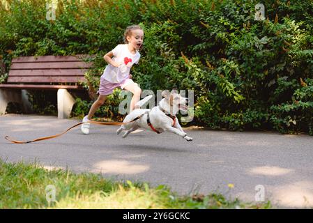 Le chien s'est détaché de sa laisse et s'enfuit du jeune propriétaire dans le parc. Banque D'Images