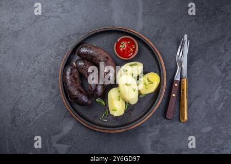 Nourriture, saucisses de sang de MORCILLA espagnoles et argentines avec pommes de terre et sauce chili Banque D'Images