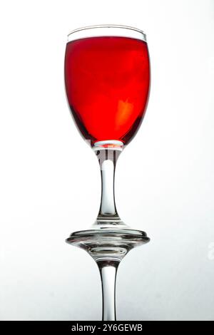 photo vue du bas du verre liquide rouge réfléchissant sur fond blanc. Banque D'Images