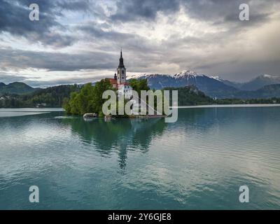 Paysage de lac saigné avec l'église de pèlerinage de l'Assomption de Maria sur une petite île après le coucher du soleil, Slovénie, Europe Banque D'Images