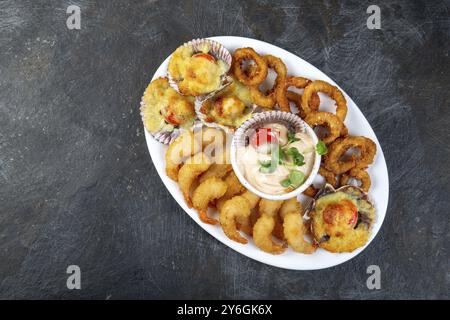 Nourriture, NOURRITURE PÉRUVIENNE. Piqueo caliente. Assiette de fruits de mer chaude crevettes frites, rondelles de calmars et noix de Saint-Jacques cuites avec sauce Banque D'Images