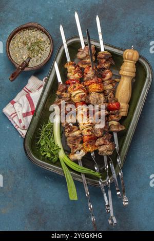 Nourriture, nourriture, barbecue viande de porc grillée, brochettes de poulet et de légumes sur plateau. Vue de dessus, pose à plat. Fond bleu Banque D'Images