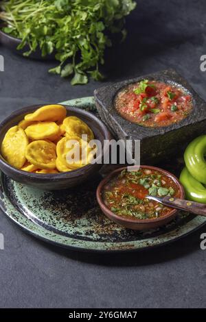 Nourriture, Sopaipilla. Cuisine latino-américaine. Sopaipillas de citrouille maison traditionnelle chilienne avec salsas typiques, sauce tomate chancho en piedra dans la pierre m Banque D'Images