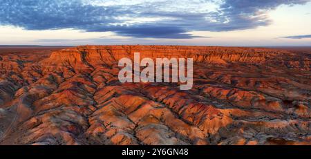 Panorama aérien de canyons rayés colorés texturaux Tsagaan suvarga, stupa blanc au lever du soleil. Soum d'Ulziit, province de Dundgovi, Mongolie, Asie Banque D'Images