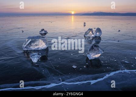 Coucher de soleil sur le paysage gelé du lac Baikal, la lumière du soleil est réfractée en morceaux de glace Banque D'Images