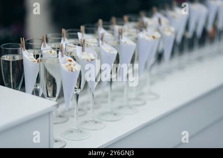 Verres avec du vin mousseux froid debout sur un comptoir dans une rangée, piscine à l'arrière, bar de fête Banque D'Images