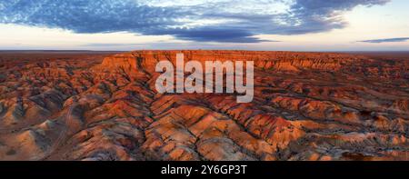 Panorama aérien de canyons rayés colorés texturaux Tsagaan suvarga, stupa blanc au lever du soleil. Soum d'Ulziit, province de Dundgovi, Mongolie, Asie Banque D'Images