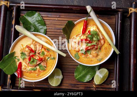 Nourriture, nourriture, crevettes Tom Yam Kung dans un bol gris avec des épices thaïlandaises sur plateau autentique vue de dessus, fond en bois Banque D'Images