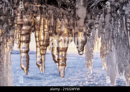 Grotte de glace sur le lac Baïkal en hiver. Glace bleue et glaçons dans la grotte dans la lumière du soleil du coucher du soleil. Île d'Olkhon, Baïkal, Sibérie, Russie, Europe Banque D'Images