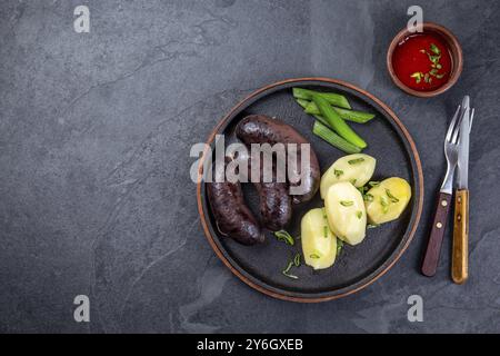 Nourriture, saucisses de sang de MORCILLA espagnoles et argentines avec pommes de terre et sauce chili Banque D'Images