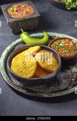 Nourriture, Sopaipilla. Cuisine latino-américaine. Sopaipillas de citrouille maison traditionnelle chilienne avec salsas typiques, sauce tomate chancho en piedra dans la pierre m Banque D'Images