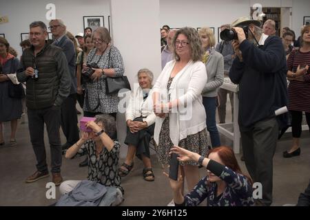 Marketa Luskacova photographe (assise les mains sur les genoux) lors d'une fête pour son exposition à la Fondation MPF Martin Parr Bristol UK. Les personnes écoutant Martin Parr . 2019, 2010s, HOMER SYKES Banque D'Images