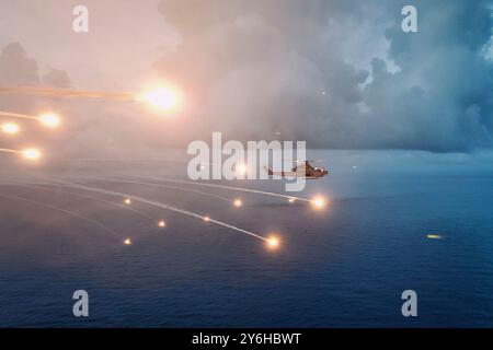 Océan Pacifique. 13 août 2024. Une Viper AH-1Z du corps des Marines des États-Unis attachée au Marine Medium Tiltrotor Squadron (VMM) 165 (renforcé), 15th Marine Expeditionary Unit, distribue des fusées éclairantes tout en menant une formation de tactique de lutte contre les menaces au-dessus de l'océan Pacifique le 1er août 2024. L'avion a été lancé depuis le navire d'assaut amphibie USS Boxer (LHD 4). Les Boxer et les éléments embarqués de la 15e MEU mènent des opérations de routine dans les zones d'opérations de la 7e flotte américaine. La 7e flotte est la plus grande flotte numérotée déployée vers l'avant des Navys des États-Unis, et interagit et opère régulièrement avec des alliés et des partenaires dans le p Banque D'Images