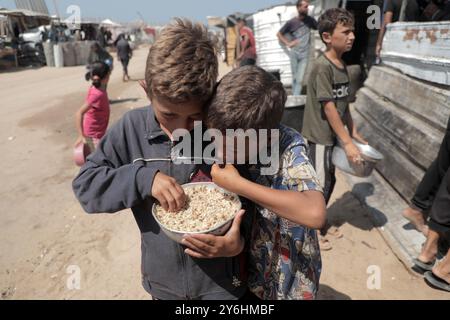 Pékin, Chine. 24 septembre 2024. Des enfants palestiniens sont vus après avoir reçu une aide alimentaire dans la ville de Khan Younis, dans le sud de la bande de Gaza, le 24 septembre 2024. Crédit : Rizek Abdeljawad /Xinhua/Alamy Live News Banque D'Images