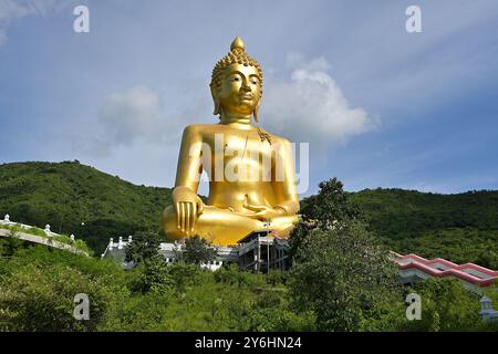 Temple thaïlandais à la base de la montagne Khao Wong Phrachan avec Bouddha doré gigantesque assis dans la pose touchant la terre ou Bhumisparsha mudra, Lopburi Banque D'Images