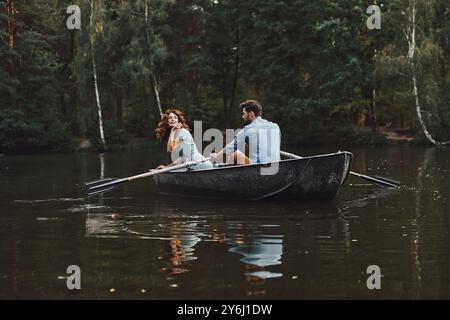 Pas de soucis. Beau jeune couple appréciant la date romantique et souriant tout en ramant un bateau Banque D'Images