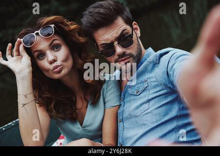 Pas de soucis et pas de règles. Autoportrait de beau jeune couple regardant la caméra tout en étant assis dans le bateau à l'extérieur Banque D'Images